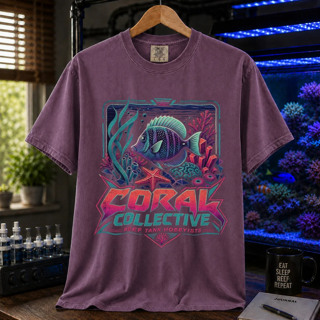 Saltwater aquarium graphic t-shirt featuring a vibrant retro-styled coral reef illustration and text: CORAL COLLECTIVE REEF TANK HOBBYISTS, purple crew neck tee