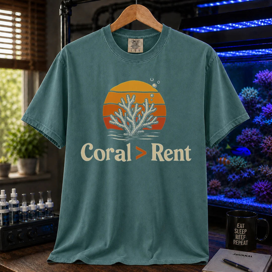 Saltwater aquarium graphic t-shirt featuring a retro sunset and coral illustration with text: Coral > Rent, green crew neck tee