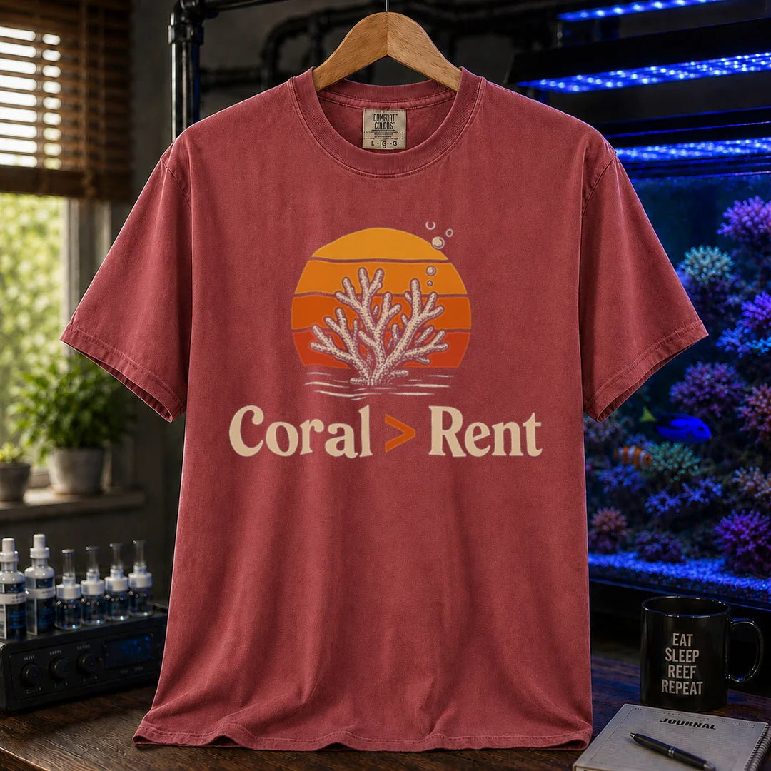 Saltwater aquarium graphic t-shirt featuring a retro sunset and coral illustration with text: Coral > Rent, maroon crew neck tee