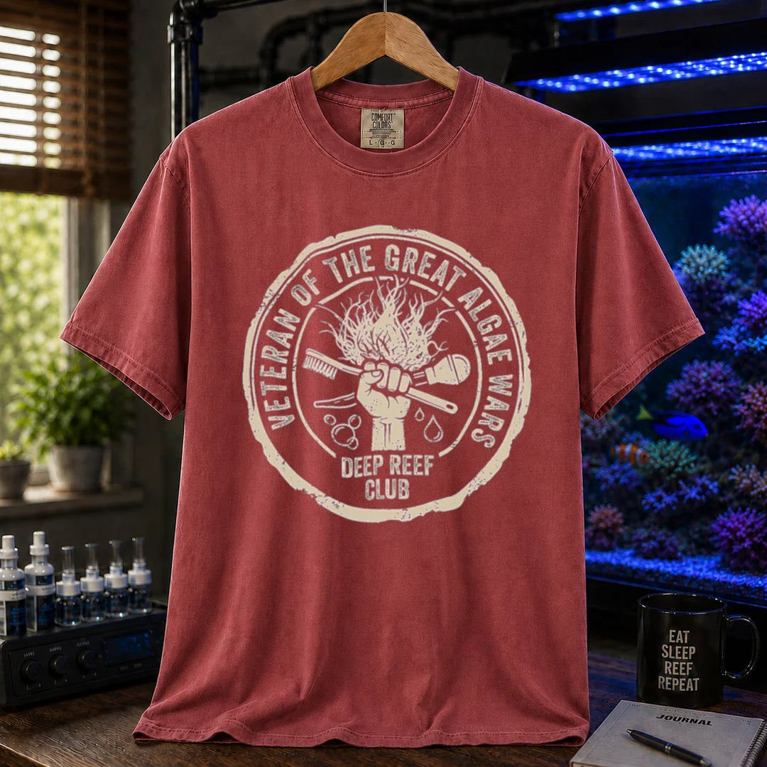 Saltwater aquarium graphic t-shirt featuring a circular emblem illustration with text: VETERAN OF THE GREAT ALGAE WARS DEEP REEF CLUB, maroon crew neck tee