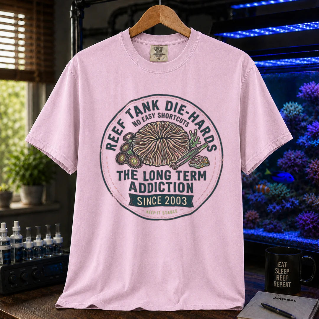 Saltwater aquarium graphic t-shirt featuring a circular vintage emblem illustration and text: REEF TANK DIE-HARDS THE LONG TERM ADDICTION SINCE 2003, pink crew neck tee