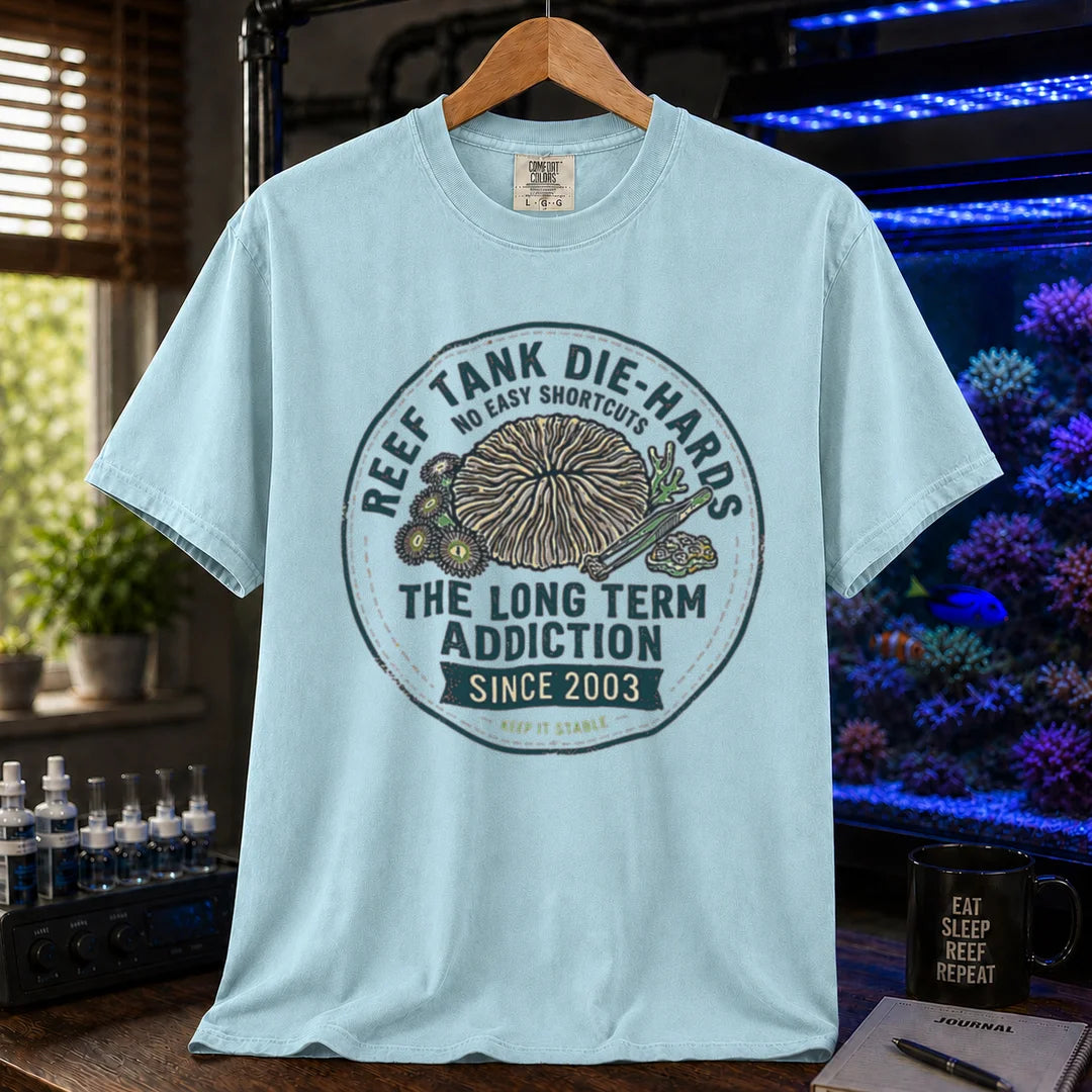 Saltwater aquarium graphic t-shirt featuring a circular vintage emblem illustration and text: REEF TANK DIE-HARDS THE LONG TERM ADDICTION SINCE 2003, light blue crew neck tee