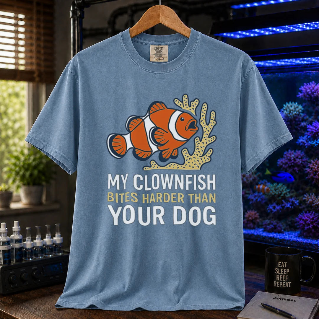 Saltwater aquarium graphic t-shirt featuring a clownfish and coral illustration with text: MY CLOWNFISH BITES HARDER THAN YOUR DOG, blue crew neck tee