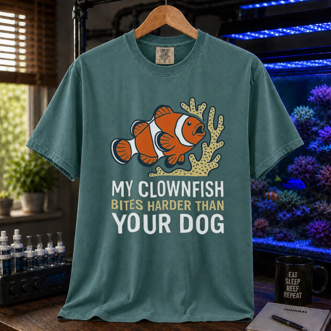 Saltwater aquarium graphic t-shirt featuring a clownfish and coral illustration with text: MY CLOWNFISH BITES HARDER THAN YOUR DOG, green crew neck tee