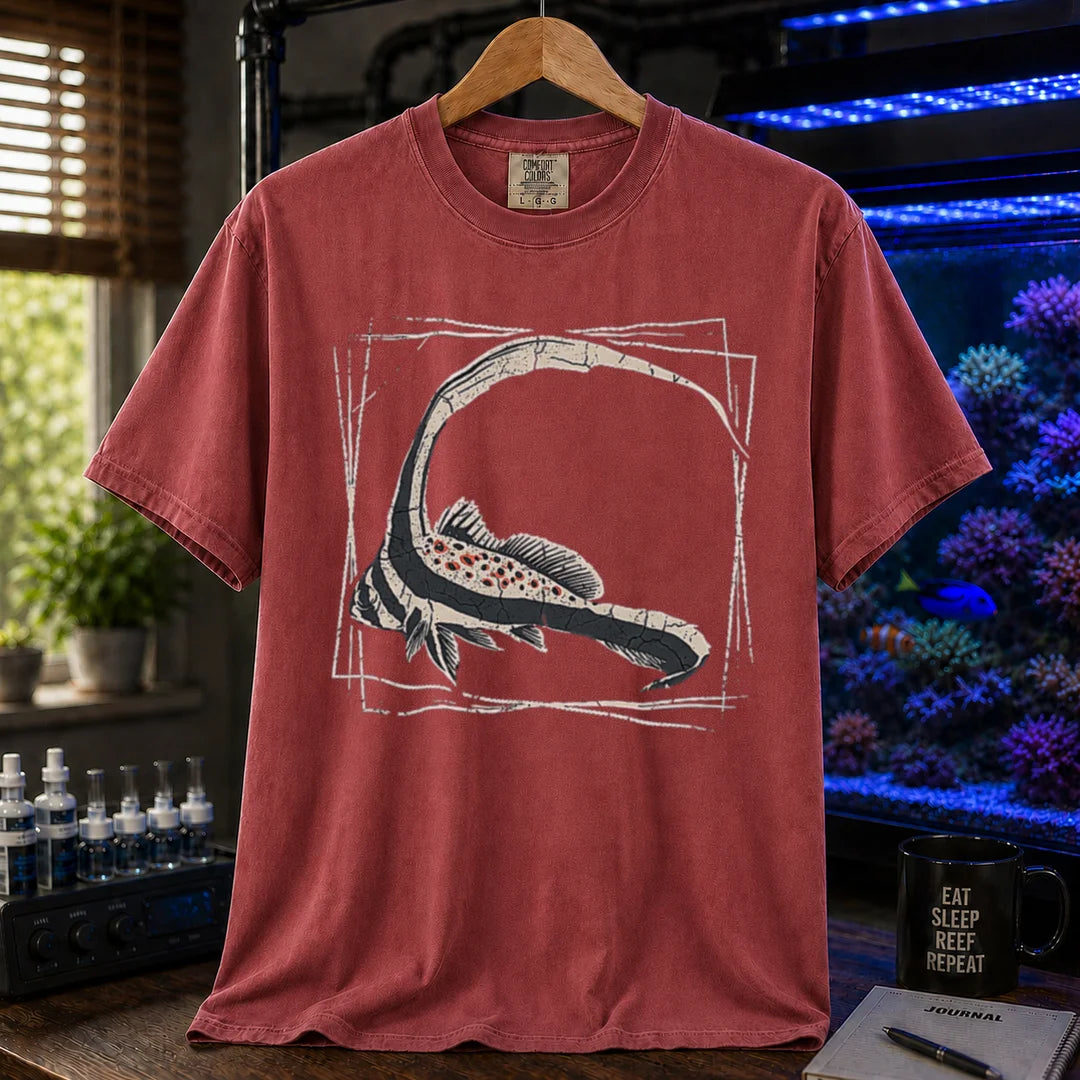 Saltwater aquarium graphic t-shirt featuring a detailed illustration of a spotted drum fish inside a geometric frame, maroon crew neck tee