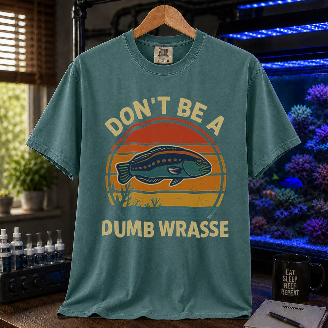Saltwater aquarium graphic t-shirt featuring a retro sunset and wrasse illustration with text: DON'T BE A DUMB WRASSE, green crew neck tee