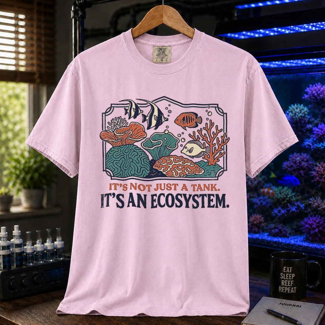 Saltwater aquarium graphic t-shirt featuring a framed biotope illustration and text: IT'S NOT JUST A TANK. IT'S AN ECOSYSTEM., pink crew neck tee