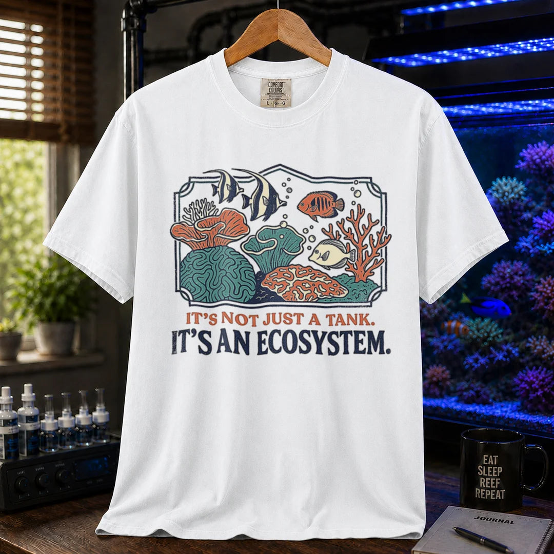 Saltwater aquarium graphic t-shirt featuring a framed biotope illustration and text: IT'S NOT JUST A TANK. IT'S AN ECOSYSTEM., white crew neck tee