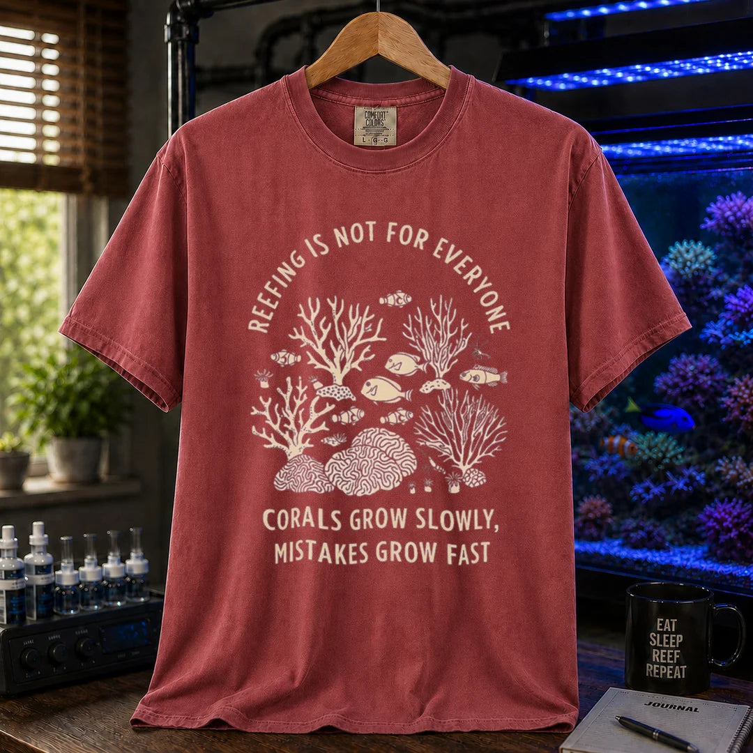 Saltwater aquarium graphic t-shirt featuring a detailed coral illustration and text: REEFING IS NOT FOR EVERYONE CORALS GROW SLOWLY, MISTAKES GROW FAST, maroon, red crew neck tee