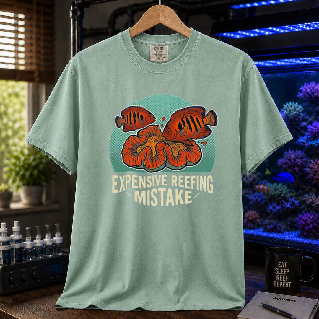 Saltwater aquarium graphic t-shirt featuring vibrant fish and coral illustrations and text: EXPENSIVE REEFING MISTAKE, light green crew neck tee