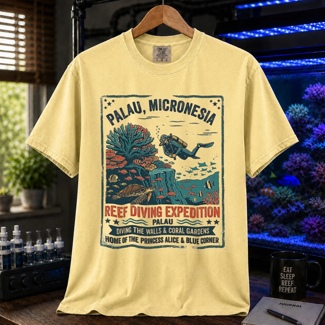 Saltwater aquarium graphic t-shirt featuring a vintage Palau diving expedition badge and text: PALAU, MICRONESIA REEF DIVING EXPEDITION, yellow crew neck tee