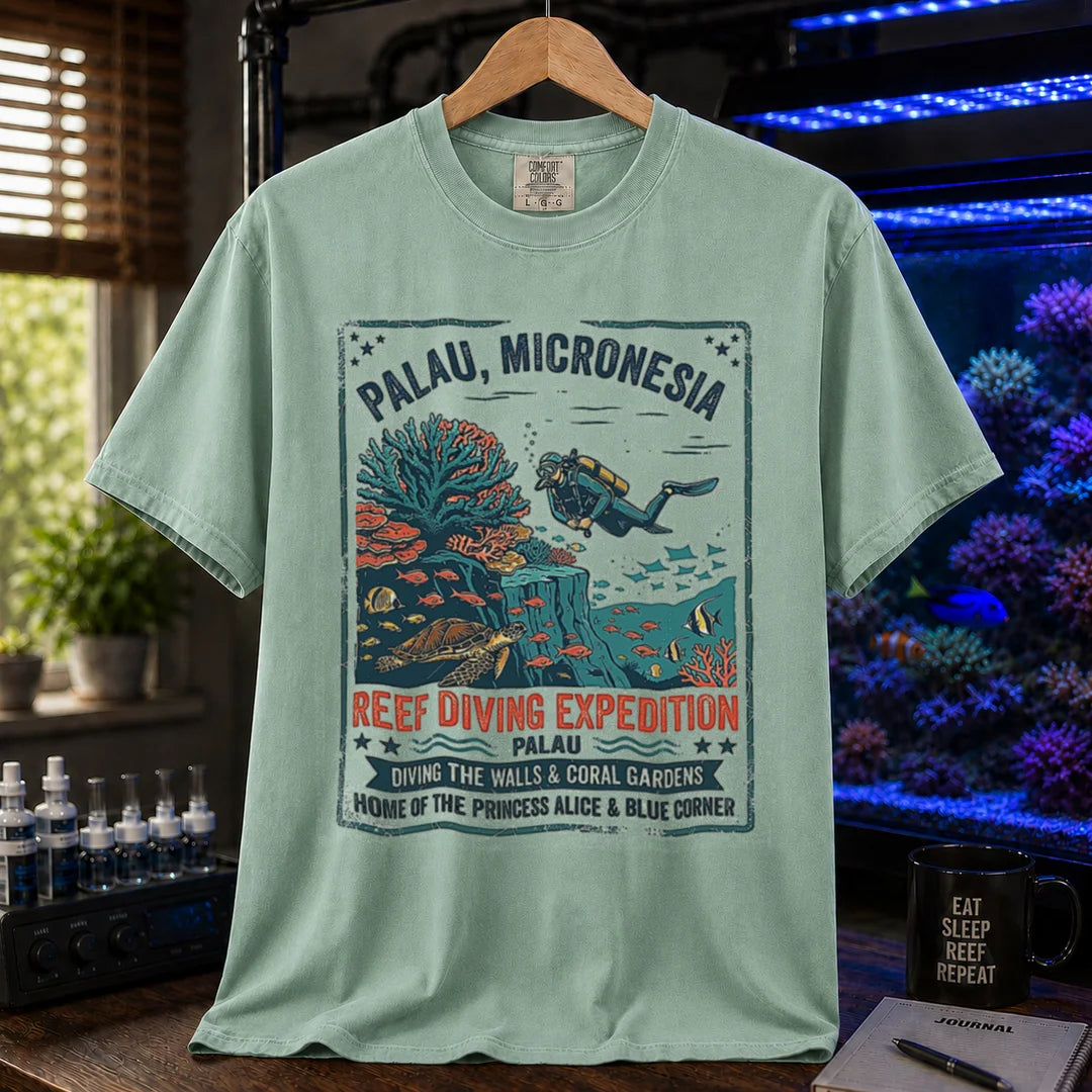Saltwater aquarium graphic t-shirt featuring a vintage Palau diving expedition badge and text: PALAU, MICRONESIA REEF DIVING EXPEDITION, green crew neck tee