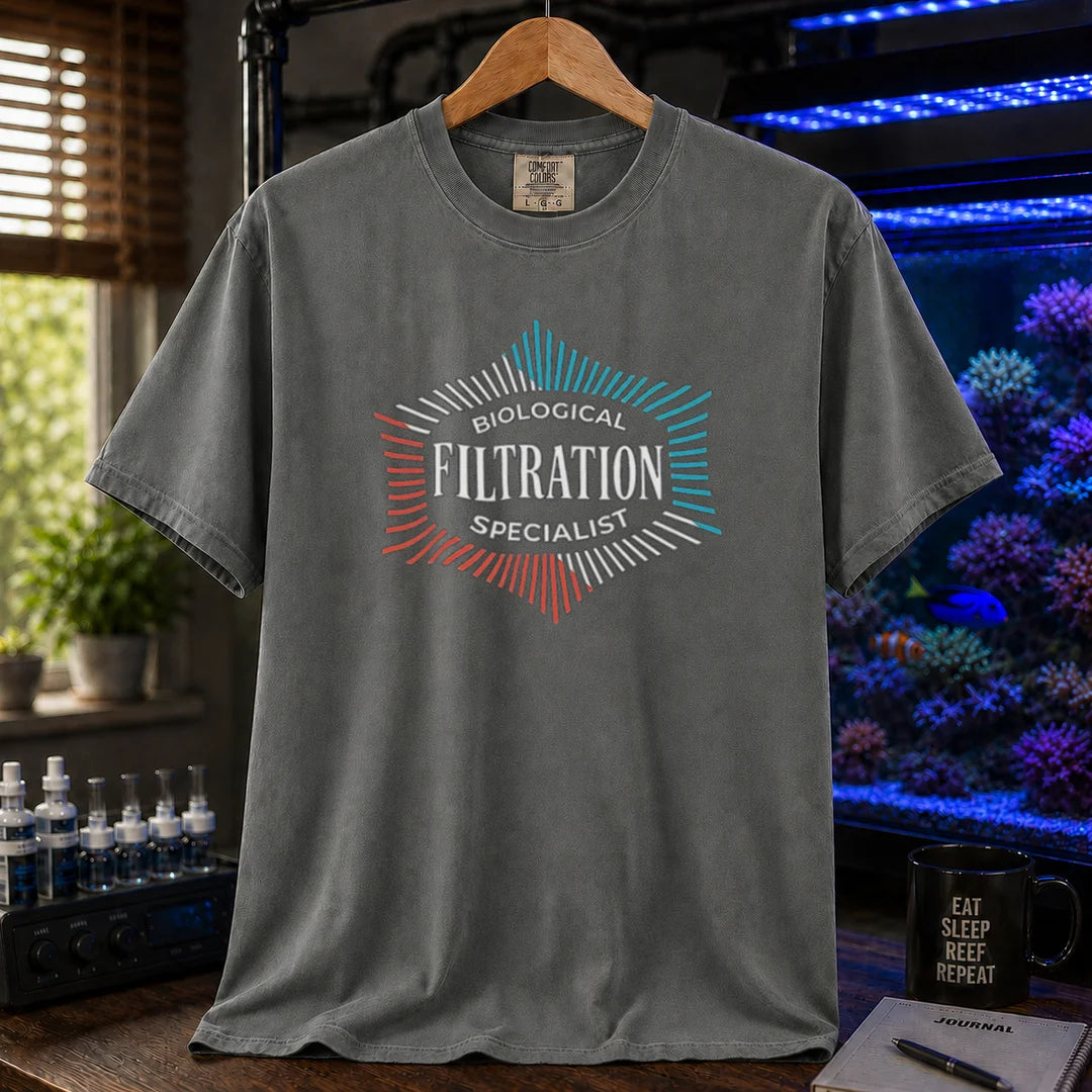 Saltwater aquarium graphic t-shirt featuring a geometric badge design and text: BIOLOGICAL FILTRATION SPECIALIST, dark grey crew neck tee