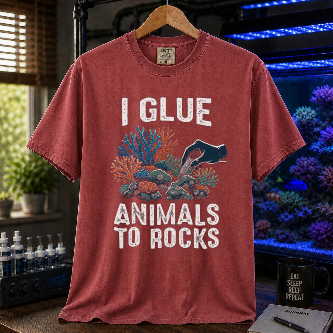 Saltwater aquarium graphic t-shirt featuring a hand gluing coral to rock illustration and text: I GLUE ANIMALS TO ROCKS, maroon, red crew neck tee