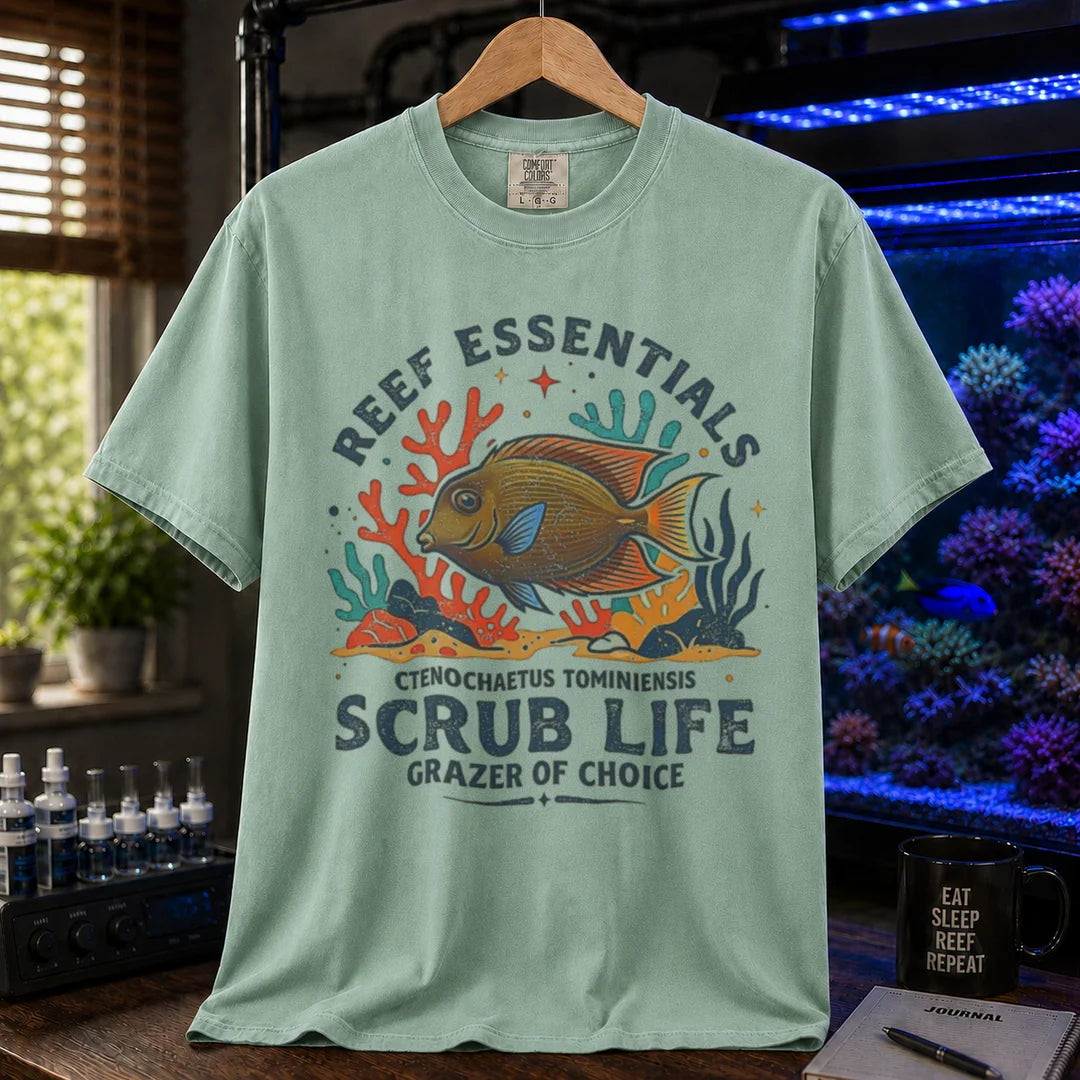 Saltwater aquarium graphic t-shirt featuring a Tomini Tang illustration and text: REEF ESSENTIALS SCRUB LIFE GRAZER OF CHOICE, green crew neck tee