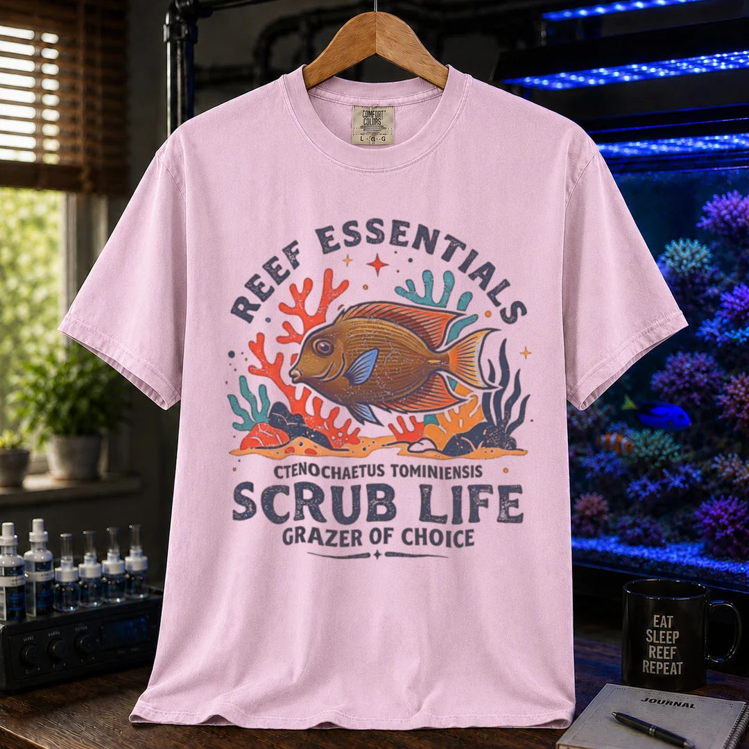 Saltwater aquarium graphic t-shirt featuring a Tomini Tang illustration and text: REEF ESSENTIALS SCRUB LIFE GRAZER OF CHOICE, pink crew neck tee