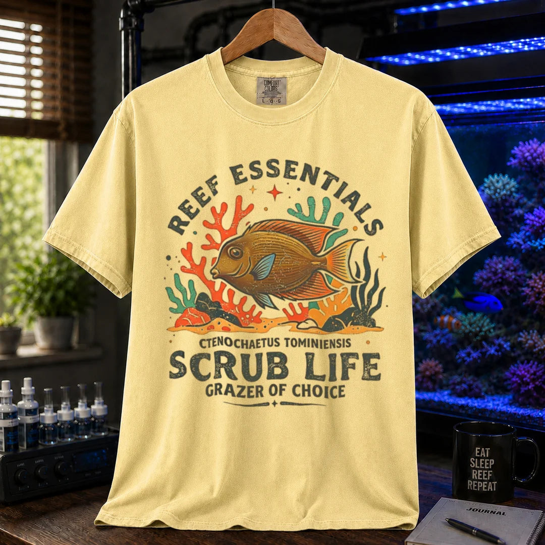 Saltwater aquarium graphic t-shirt featuring a Tomini Tang illustration and text: REEF ESSENTIALS SCRUB LIFE GRAZER OF CHOICE, yellow crew neck tee