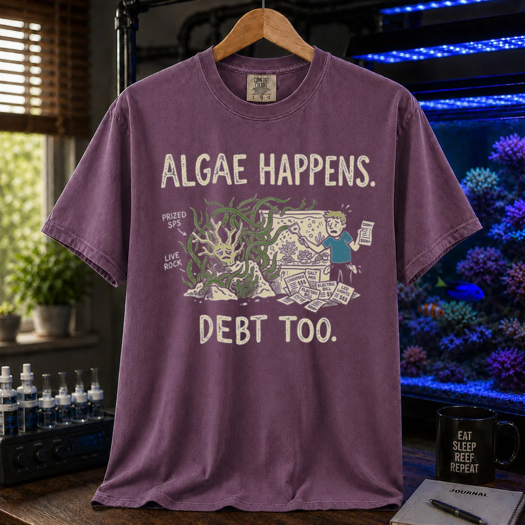 Saltwater aquarium graphic t-shirt featuring an overgrown tank and stressed aquarist illustration with text: ALGAE HAPPENS. DEBT TOO., purple crew neck tee