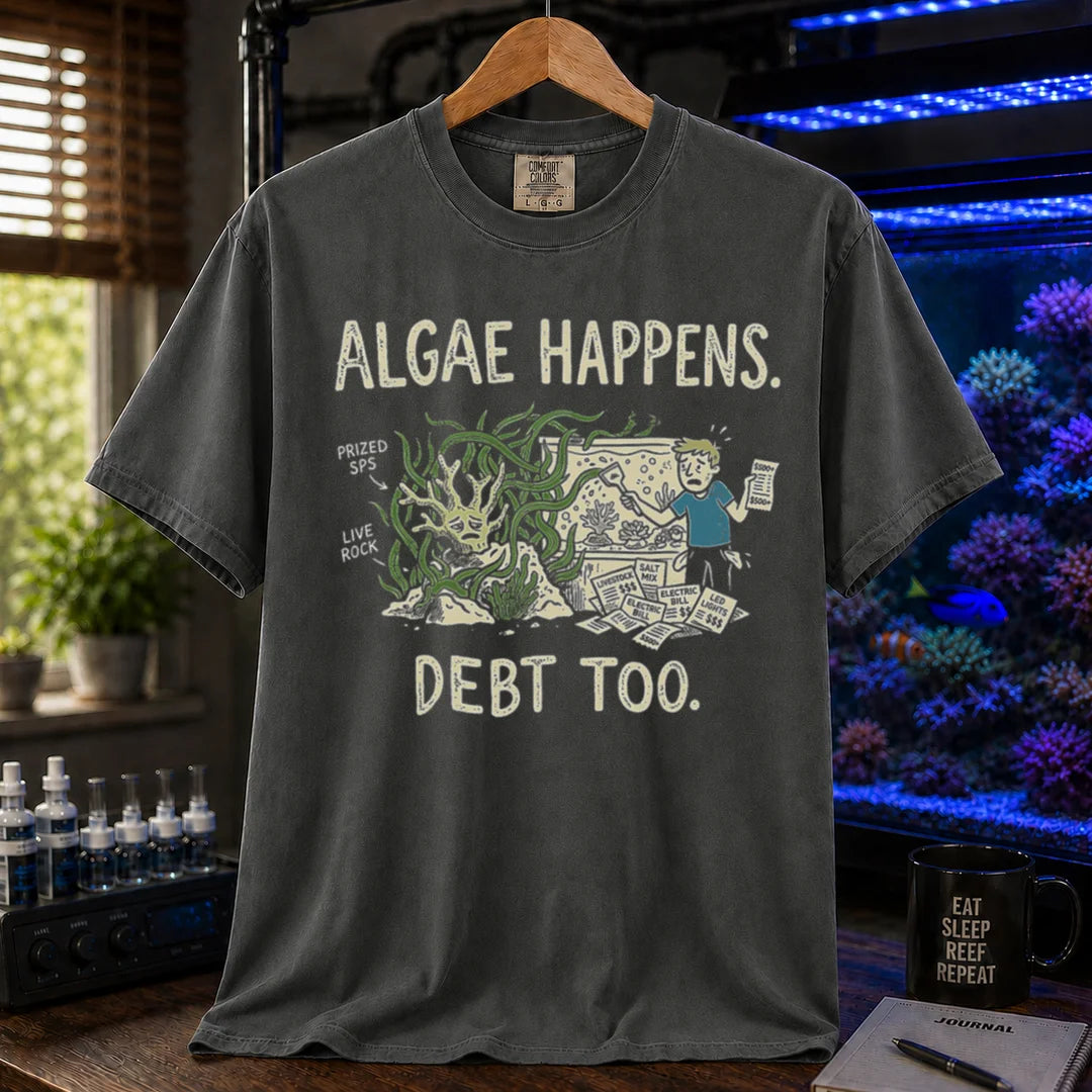 Saltwater aquarium graphic t-shirt featuring an overgrown tank and stressed aquarist illustration with text: ALGAE HAPPENS. DEBT TOO., dark grey crew neck tee