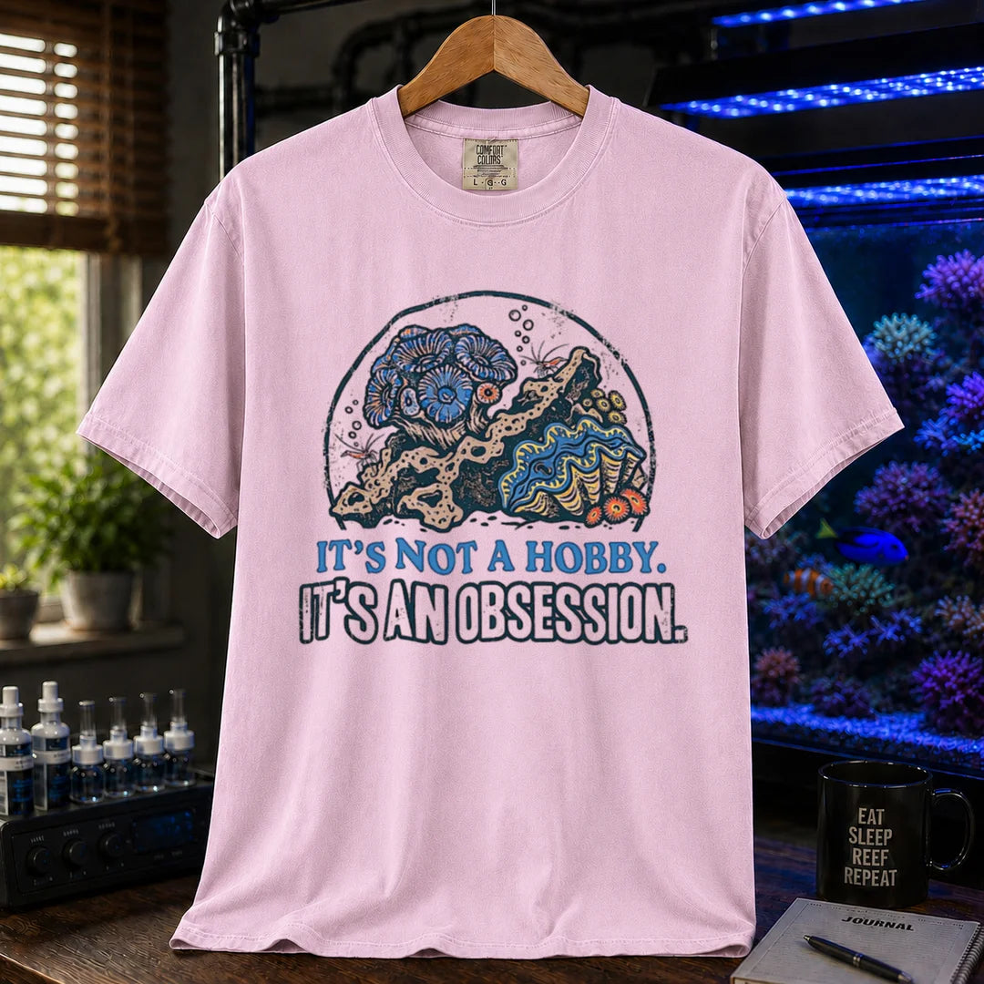 Saltwater aquarium graphic t-shirt featuring a reef aquascape illustration and text: IT'S NOT A HOBBY. IT'S AN OBSESSION., pink crew neck tee