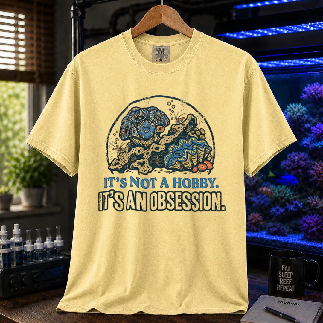 Saltwater aquarium graphic t-shirt featuring a reef aquascape illustration and text: IT'S NOT A HOBBY. IT'S AN OBSESSION., yellow crew neck tee