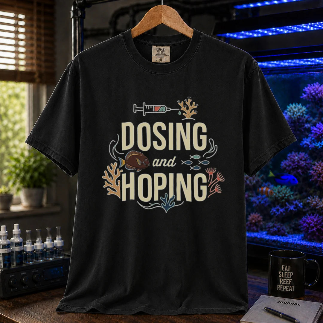 Saltwater aquarium graphic t-shirt featuring a dosing syringe and coral illustration with text: DOSING and HOPING, black crew neck tee