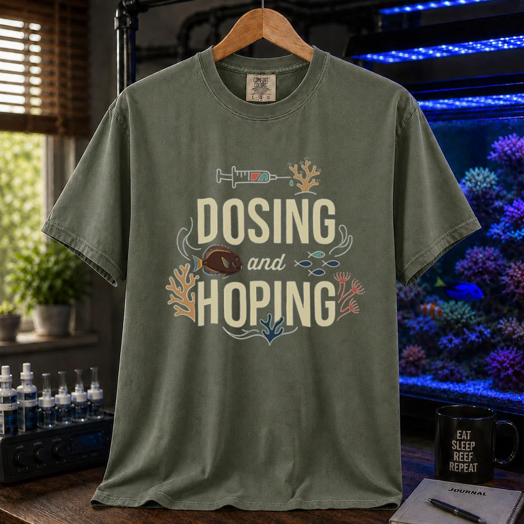 Saltwater aquarium graphic t-shirt featuring a dosing syringe and coral illustration with text: DOSING and HOPING, military green crew neck tee