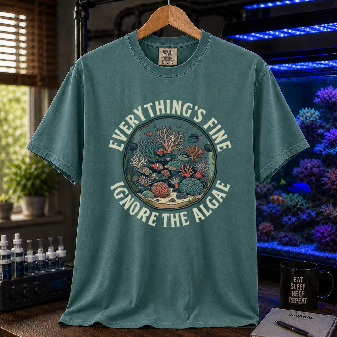 Saltwater aquarium graphic t-shirt featuring a circular reef tank illustration and curved text: EVERYTHING'S FINE IGNORE THE ALGAE, green crew neck tee