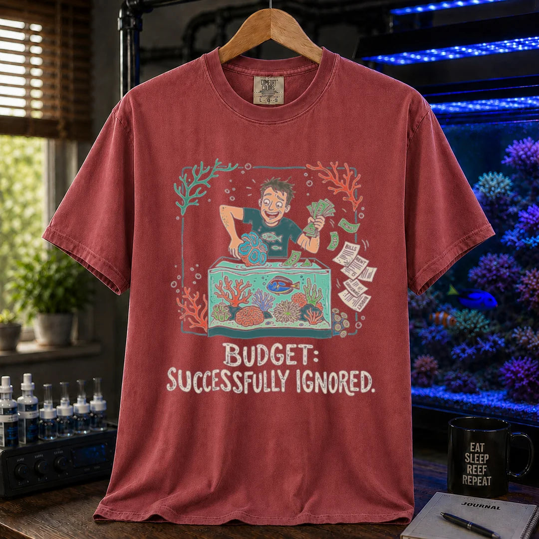 Saltwater aquarium graphic t-shirt featuring an aquarist tossing bills into a tank illustration with text: BUDGET: SUCCESSFULLY IGNORED., maroon, red crew neck tee