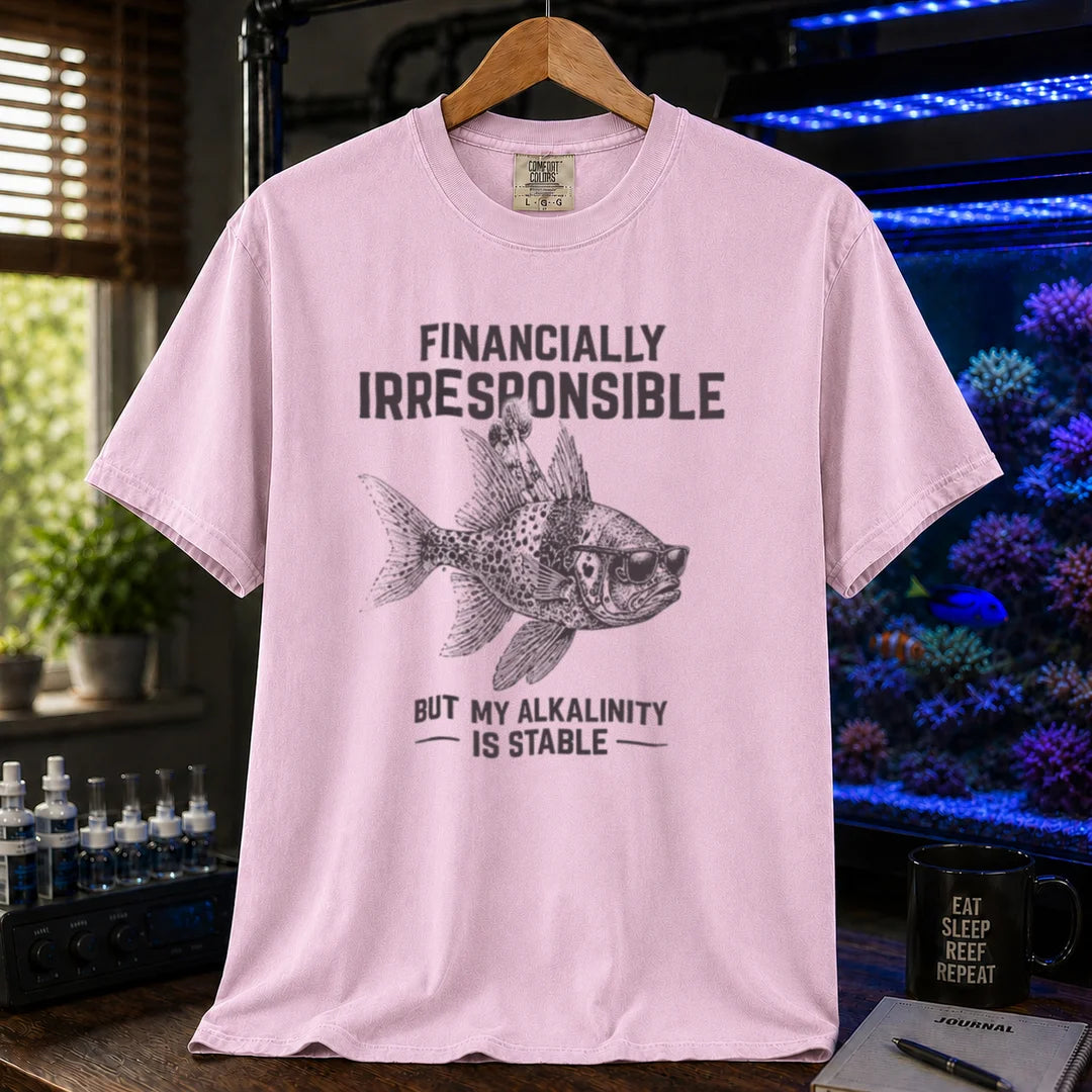 Saltwater aquarium graphic t-shirt featuring a fish in sunglasses illustration and text: FINANCIALLY IRRESPONSIBLE BUT MY ALKALINITY IS STABLE, pink crew neck tee