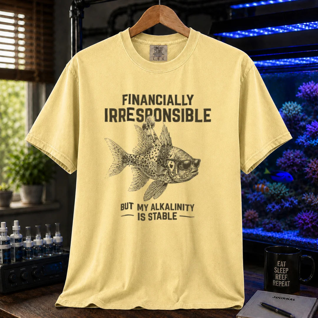 Saltwater aquarium graphic t-shirt featuring a fish in sunglasses illustration and text: FINANCIALLY IRRESPONSIBLE BUT MY ALKALINITY IS STABLE, yellow crew neck tee
