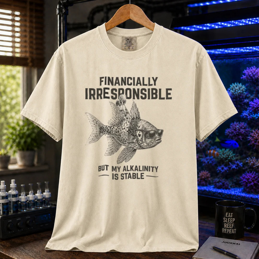 Saltwater aquarium graphic t-shirt featuring a fish in sunglasses illustration and text: FINANCIALLY IRRESPONSIBLE BUT MY ALKALINITY IS STABLE, cream, beige, ivory crew neck tee