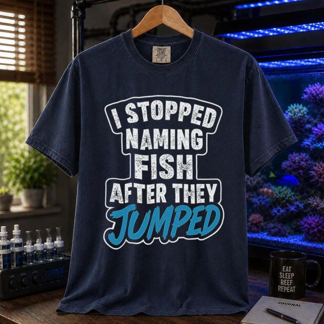 Saltwater aquarium graphic t-shirt featuring distressed block text and blue script: I STOPPED NAMING FISH AFTER THEY JUMPED, navy crew neck tee