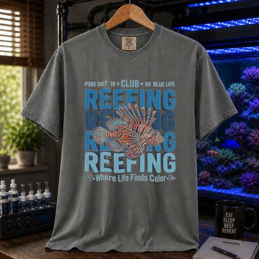 Saltwater aquarium graphic t-shirt featuring a lionfish illustration and repeated text: REEFING Where Life Finds Color, dark grey crew neck tee