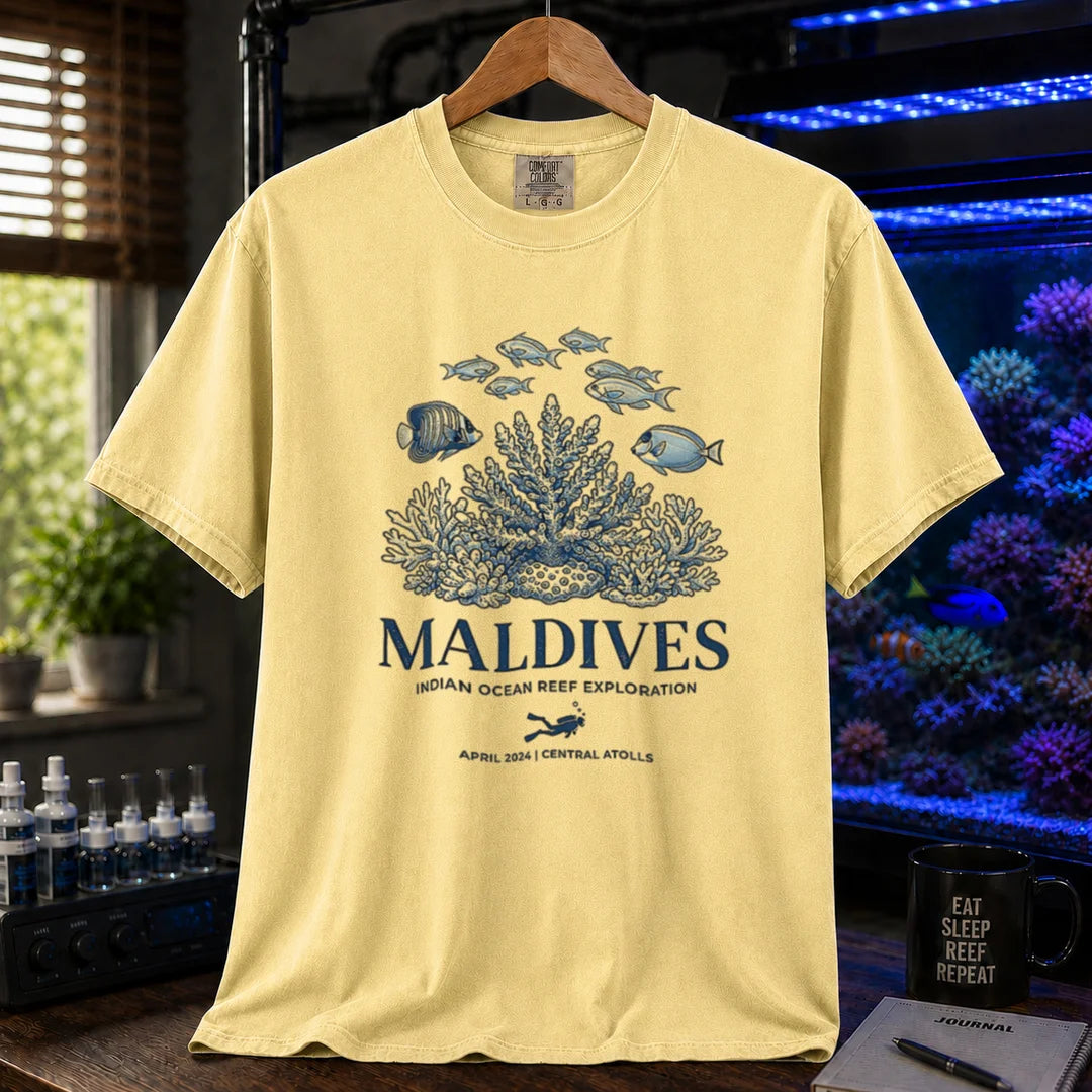 Saltwater aquarium graphic t-shirt featuring a coral reef and fish illustration with text: MALDIVES INDIAN OCEAN REEF EXPLORATION APRIL 2024 CENTRAL ATOLLS, yellow crew neck tee