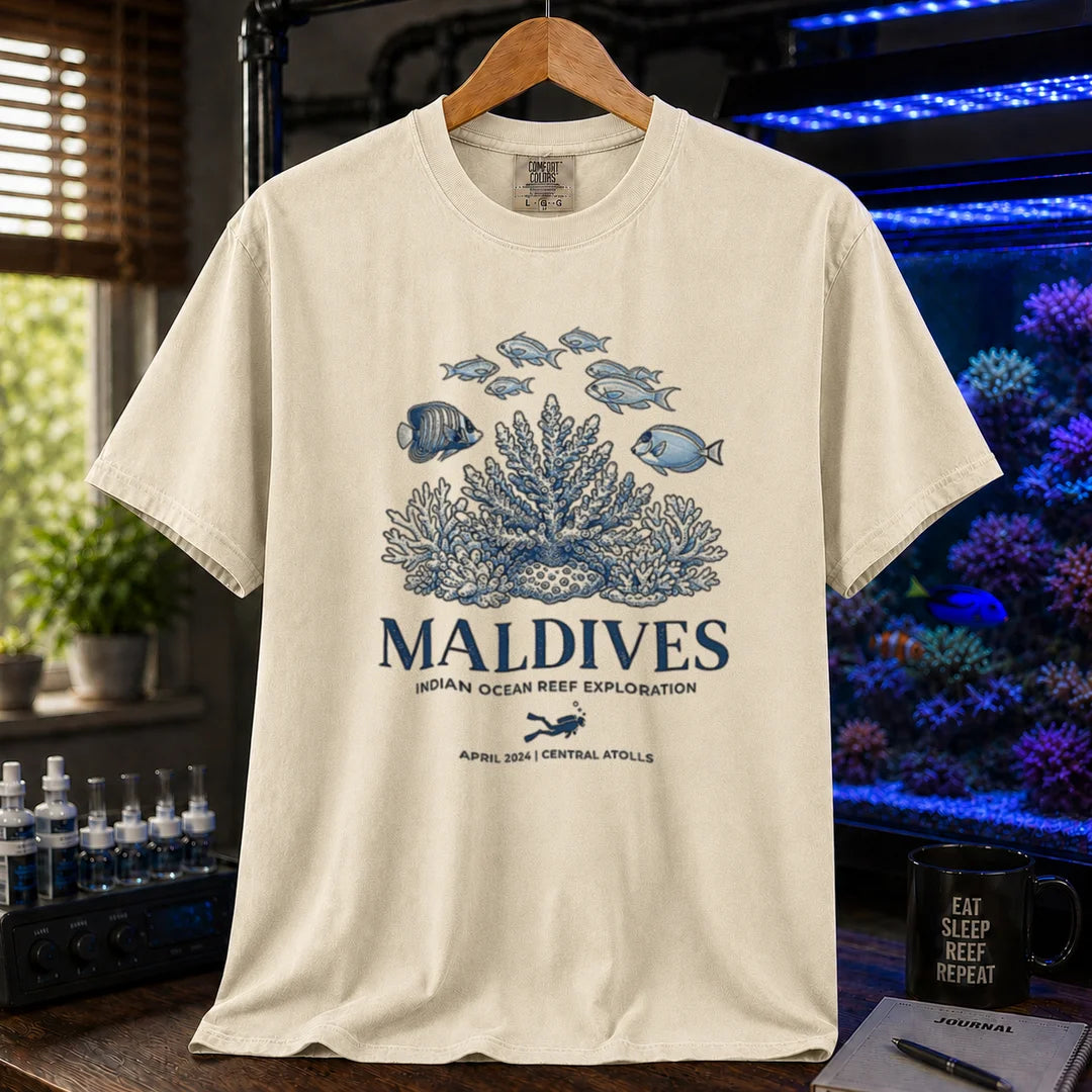 Saltwater aquarium graphic t-shirt featuring a coral reef and fish illustration with text: MALDIVES INDIAN OCEAN REEF EXPLORATION APRIL 2024 CENTRAL ATOLLS, cream, beige, ivory crew neck tee