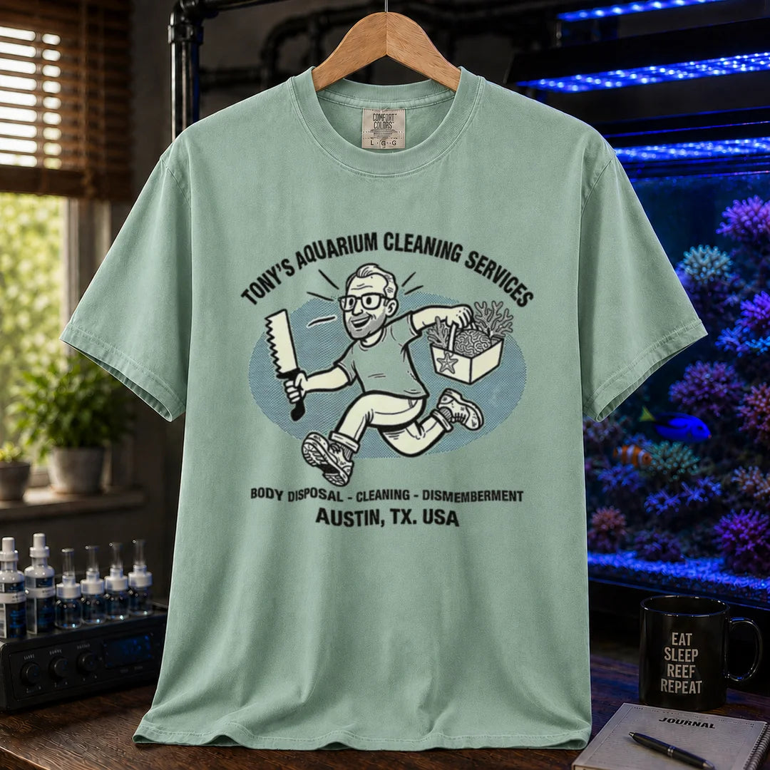 Saltwater aquarium graphic t-shirt featuring a cartoon illustration and text: TONY'S AQUARIUM CLEANING SERVICES BODY DISPOSAL - CLEANING - DISMEMBERMENT AUSTIN, TX. USA, green crew neck tee