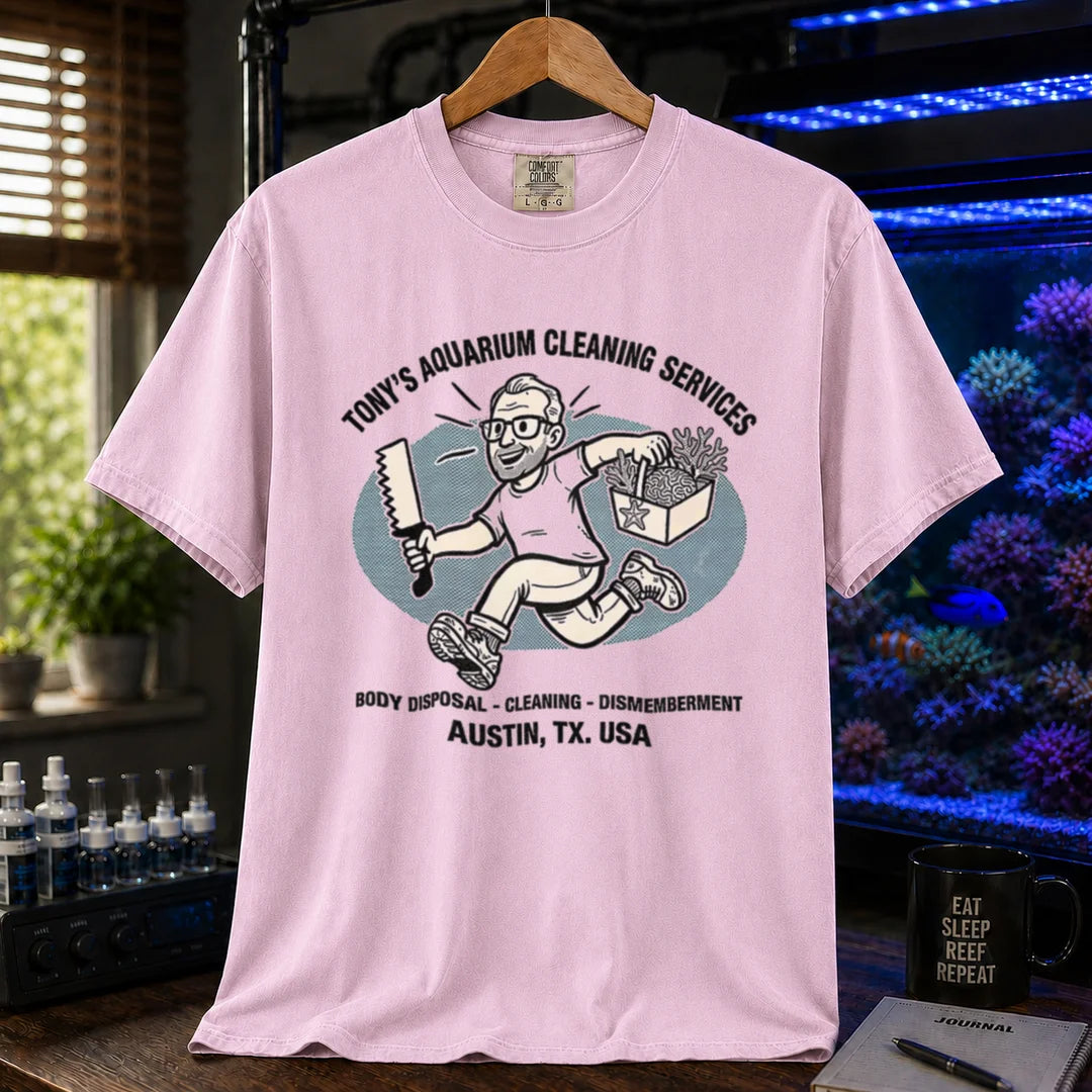 Saltwater aquarium graphic t-shirt featuring a cartoon illustration and text: TONY'S AQUARIUM CLEANING SERVICES BODY DISPOSAL - CLEANING - DISMEMBERMENT AUSTIN, TX. USA, pink crew neck tee