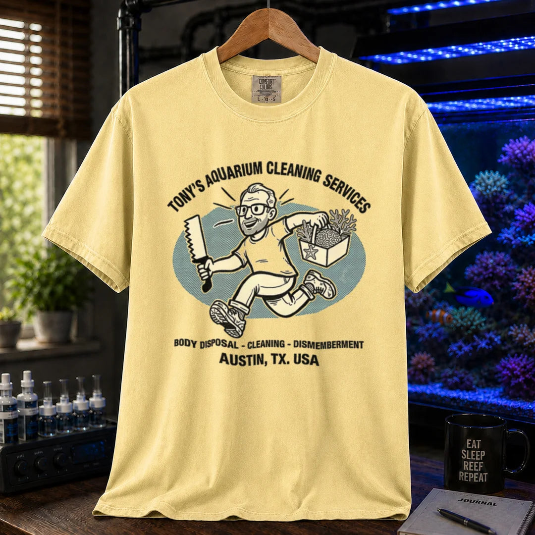 Saltwater aquarium graphic t-shirt featuring a cartoon illustration and text: TONY'S AQUARIUM CLEANING SERVICES BODY DISPOSAL - CLEANING - DISMEMBERMENT AUSTIN, TX. USA, yellow crew neck tee