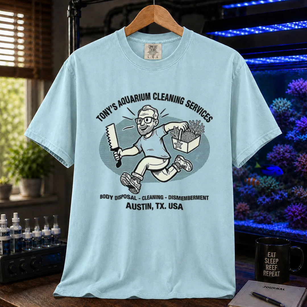 Saltwater aquarium graphic t-shirt featuring a cartoon illustration and text: TONY'S AQUARIUM CLEANING SERVICES BODY DISPOSAL - CLEANING - DISMEMBERMENT AUSTIN, TX. USA, blue crew neck tee