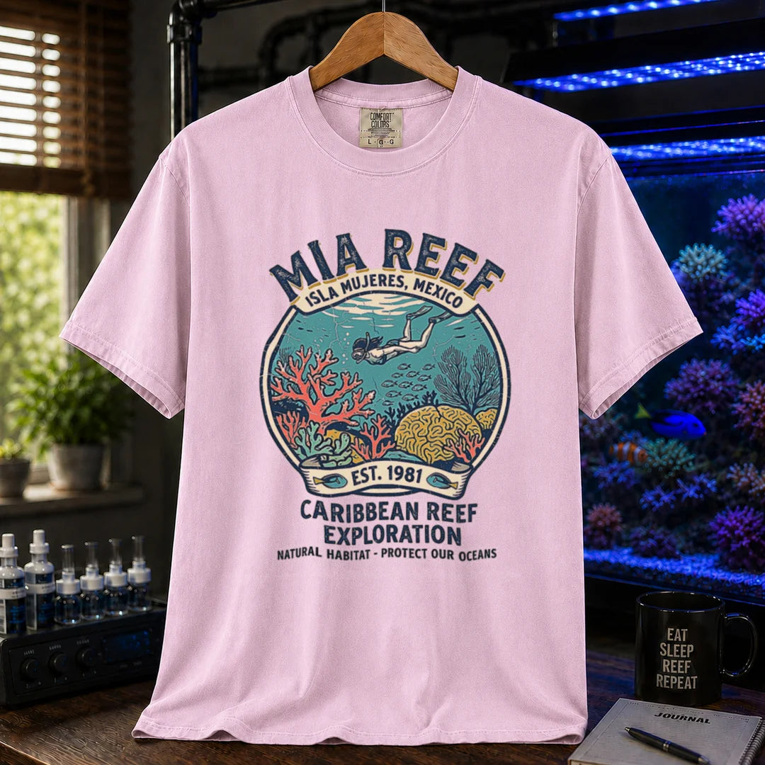 Saltwater aquarium graphic t-shirt featuring a circular diver and coral reef emblem with text: MIA REEF ISLA MUJERES, MEXICO CARIBBEAN REEF EXPLORATION NATURAL HABITAT - PROTECT OUR OCEANS, pink crew neck tee
