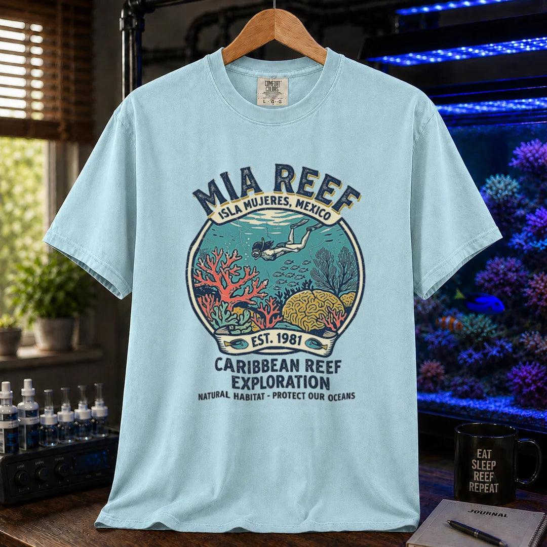 Saltwater aquarium graphic t-shirt featuring a circular diver and coral reef emblem with text: MIA REEF ISLA MUJERES, MEXICO CARIBBEAN REEF EXPLORATION NATURAL HABITAT - PROTECT OUR OCEANS, light blue crew neck tee