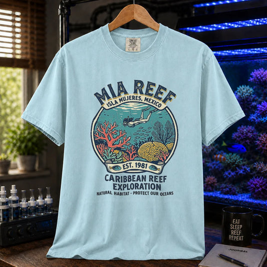 Saltwater aquarium graphic t-shirt featuring a circular diver and coral reef emblem with text: MIA REEF ISLA MUJERES, MEXICO CARIBBEAN REEF EXPLORATION NATURAL HABITAT - PROTECT OUR OCEANS, light blue crew neck tee