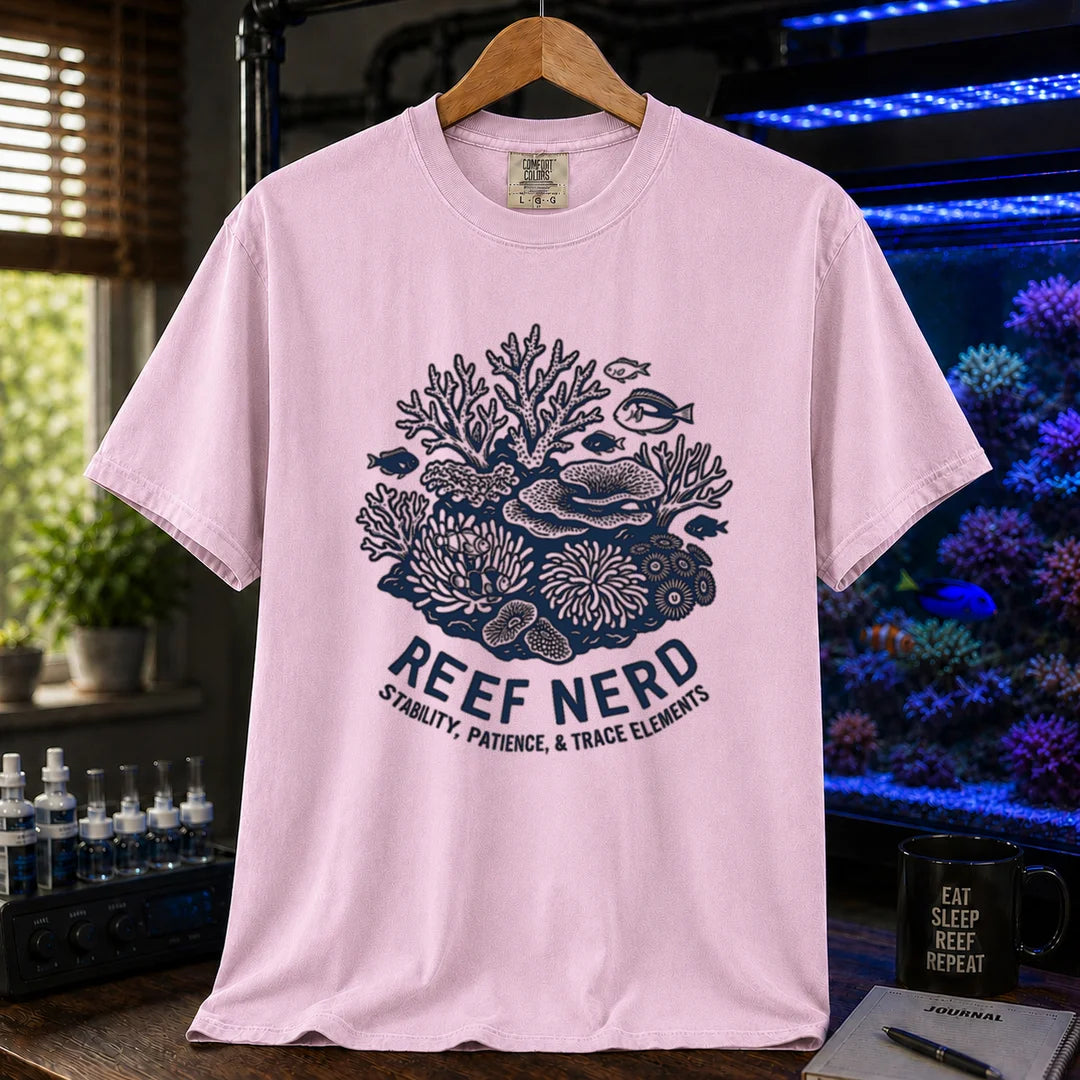 Saltwater aquarium graphic t-shirt featuring a detailed coral reef illustration with text: REEF NERD STABILITY, PATIENCE, & TRACE ELEMENTS, pink crew neck tee