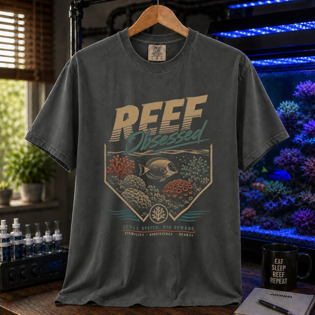 Saltwater aquarium graphic t-shirt featuring a retro coral emblem and text: REEF Obsessed SMALL SYSTEM. BIG REWARD. STABILITY . CONSISTENCY . BEAUTY, dark grey crew neck tee