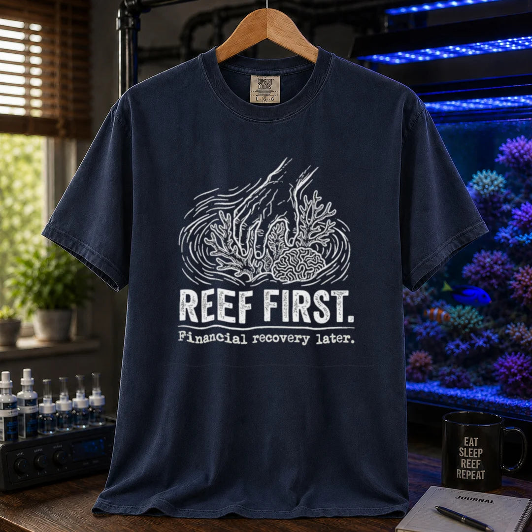Saltwater aquarium graphic t-shirt featuring a hand tending corals illustration and text: REEF FIRST. Financial recovery later., navy crew neck tee