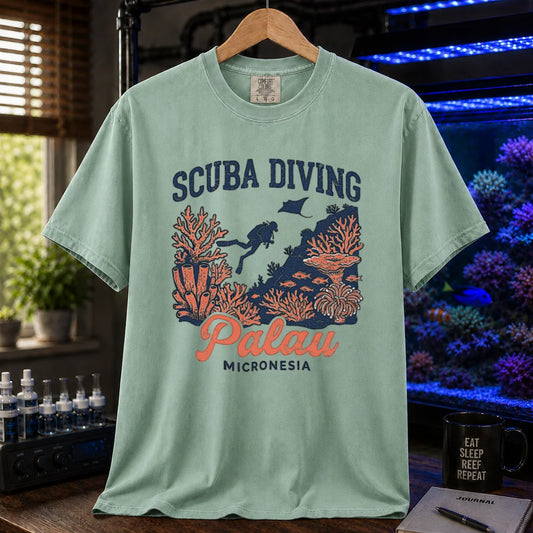 Saltwater aquarium graphic t-shirt featuring a scuba diver and coral reef illustration with text: SCUBA DIVING Palau MICRONESIA, green crew neck tee
