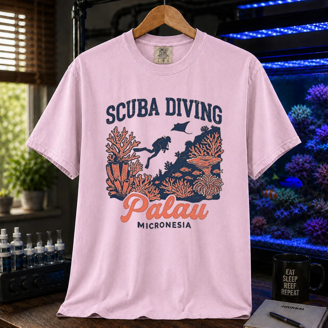 Saltwater aquarium graphic t-shirt featuring a scuba diver and coral reef illustration with text: SCUBA DIVING Palau MICRONESIA, pink crew neck tee