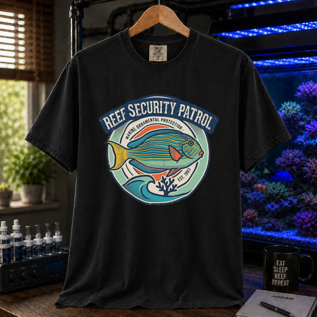 Saltwater aquarium graphic t-shirt featuring a circular emblem with a reef fish illustration and text: REEF SECURITY PATROL MARINE ORNAMENTAL PROTECTION EST. 1983, black crew neck tee