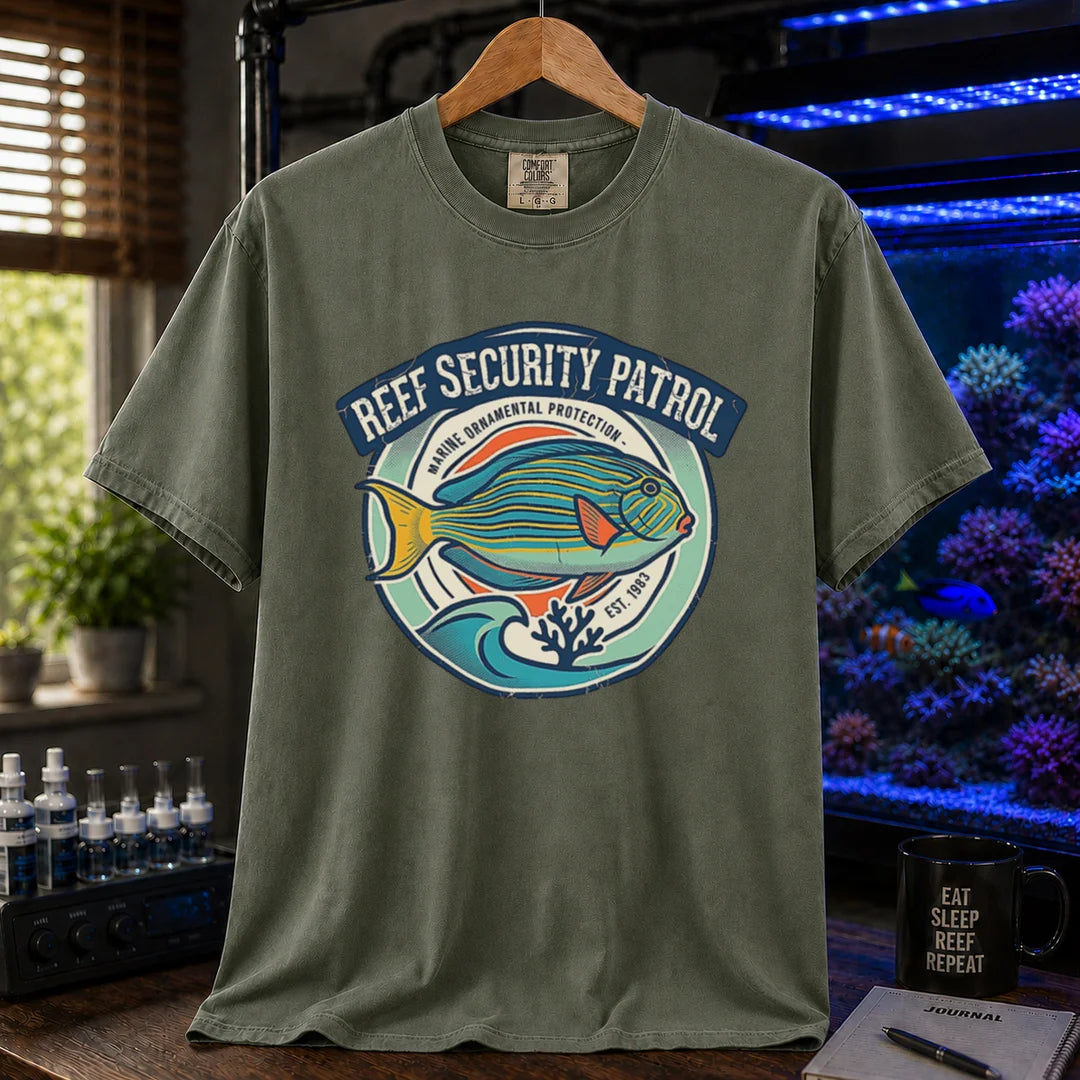 Saltwater aquarium graphic t-shirt featuring a circular emblem with a reef fish illustration and text: REEF SECURITY PATROL MARINE ORNAMENTAL PROTECTION EST. 1983, military green crew neck tee